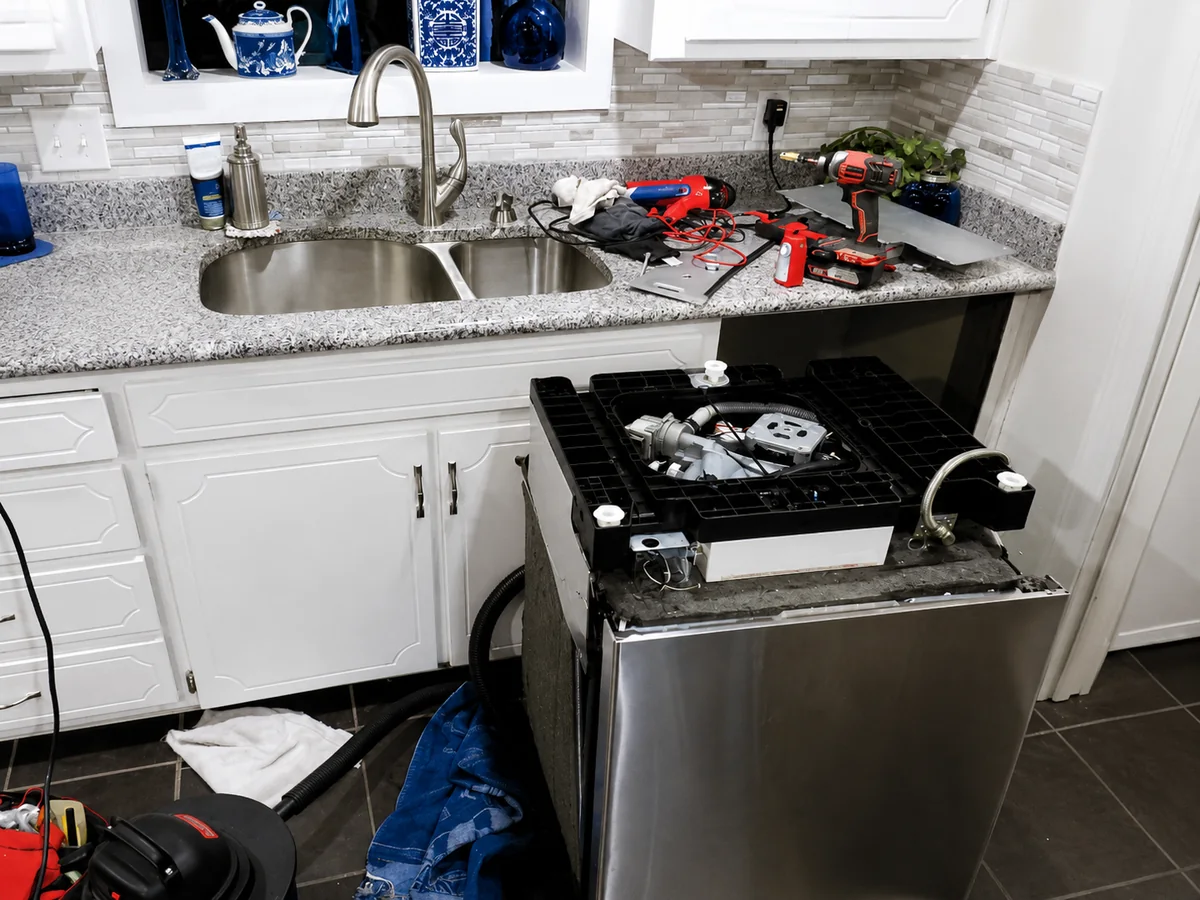 Dishwasher pulled out for professional repair and maintenance